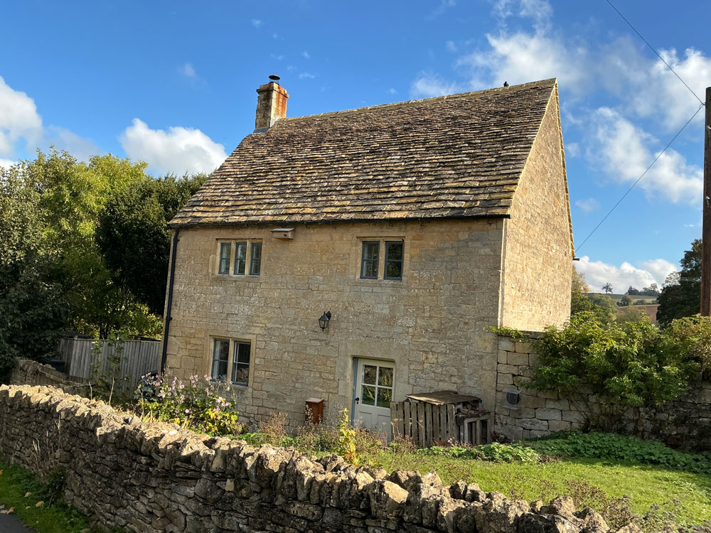 Steep-pitched cottage with a new Cotswold stone slate roof
