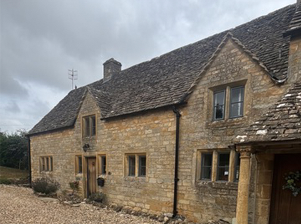 Farmhouse with gabled dormers before re-roofing