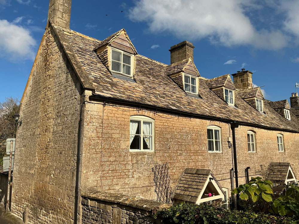 Terrace of dormer cottages with a new Cotswold stone slate roof