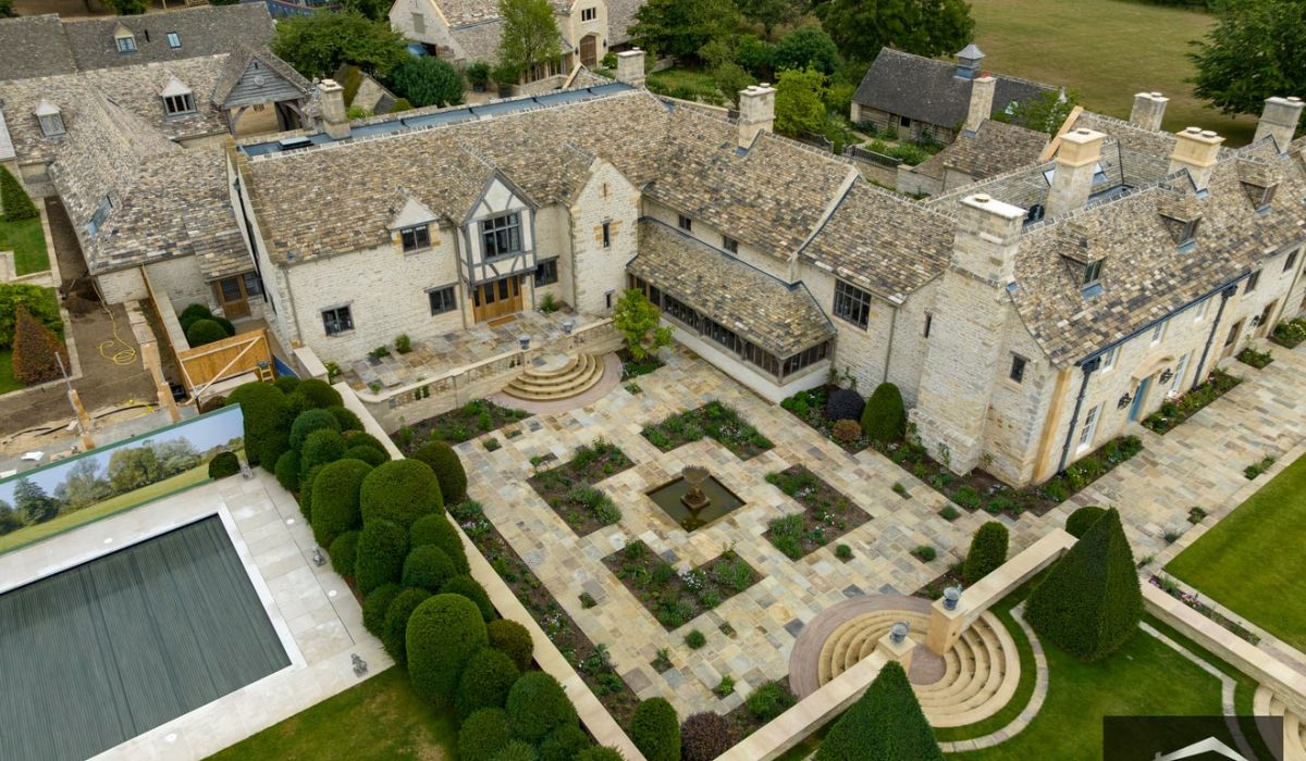 Aerial view of a house under construction, showcasing the framework and surrounding site preparations. 