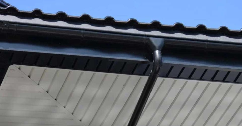 A black and white roof featuring a prominent white gutter along the edge.  